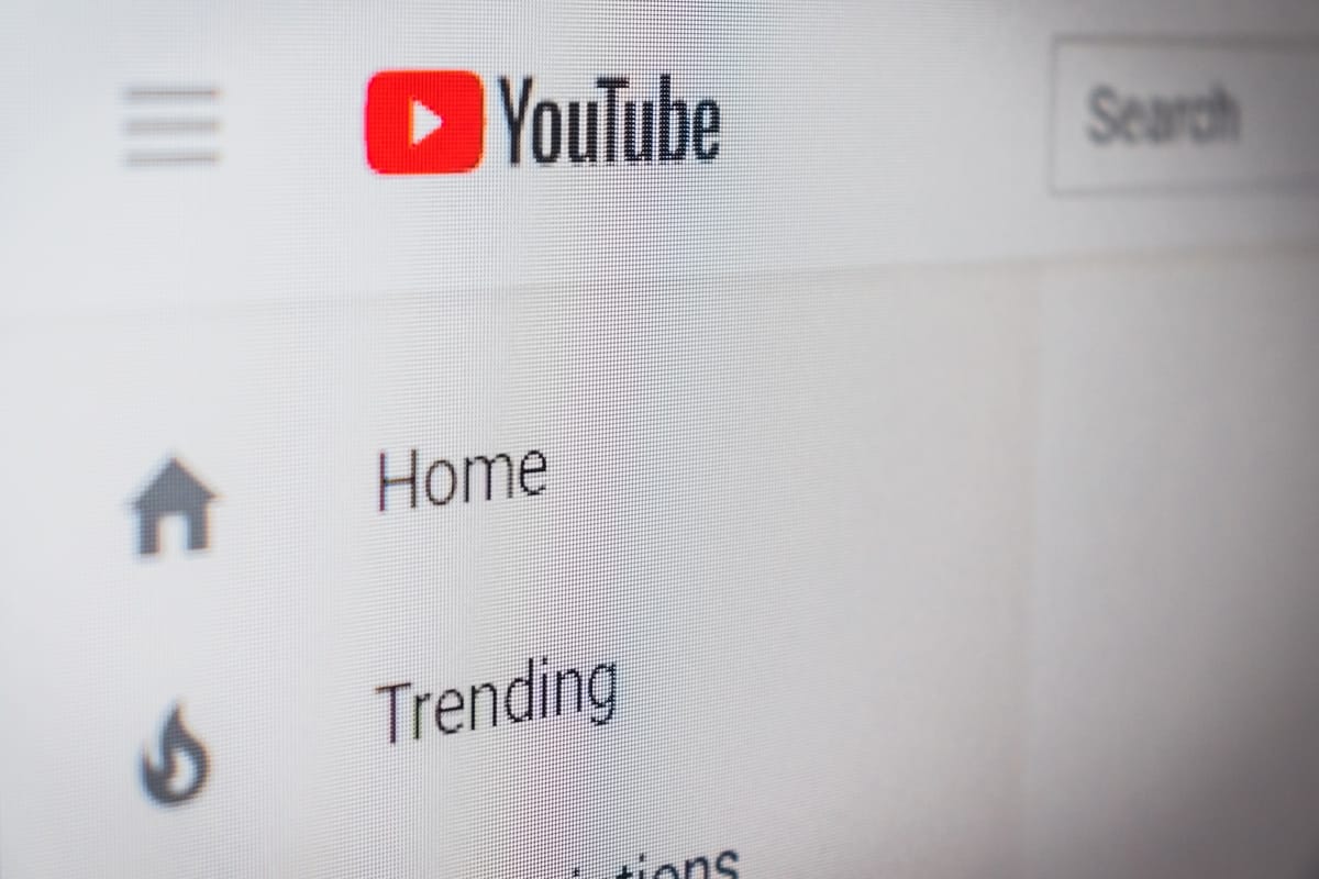 Close-up of YouTube website interface showing the logo, Home and Trending navigation options on a desktop screen.